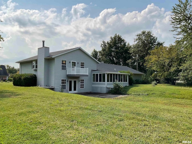 rear view of property with a sunroom, a yard, and a patio area