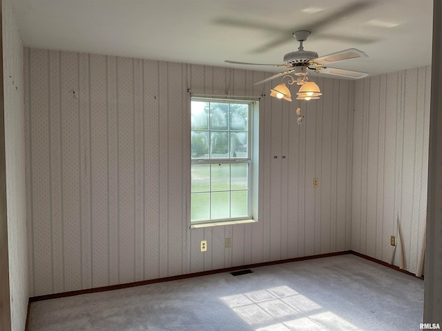 carpeted spare room featuring ceiling fan