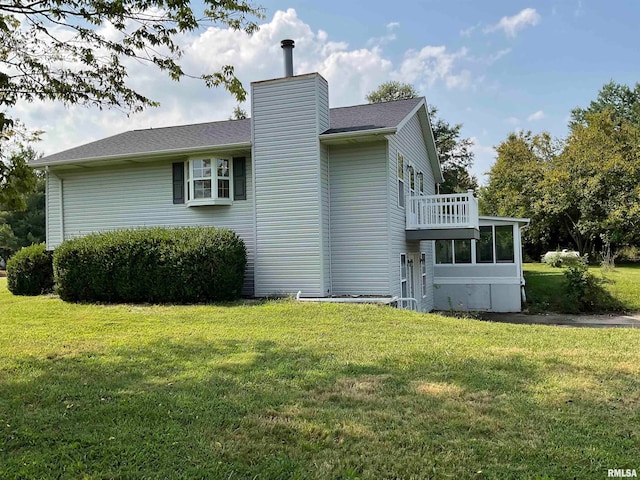 view of side of home with a balcony and a lawn