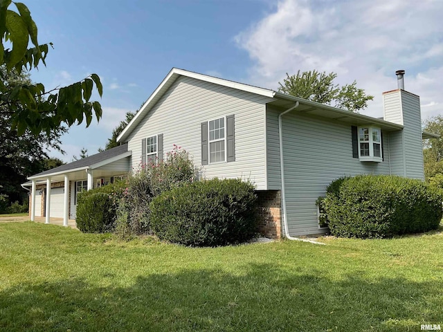 view of side of home featuring a garage and a lawn