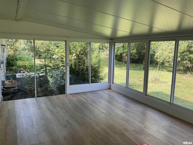 unfurnished sunroom featuring vaulted ceiling with beams