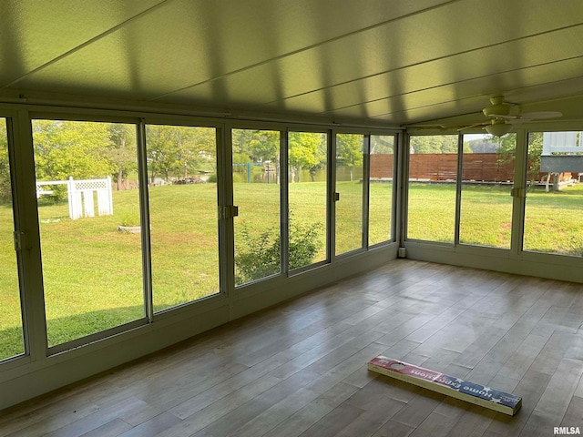 unfurnished sunroom with ceiling fan and vaulted ceiling