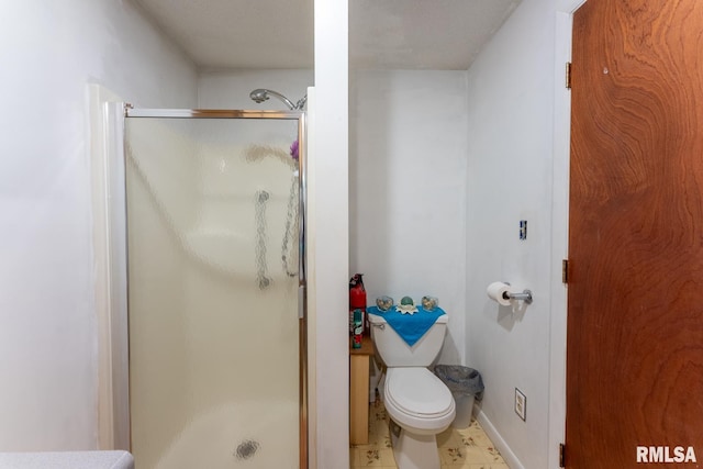 bathroom featuring toilet and a shower with shower door