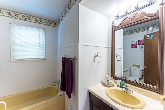 25 Lees Dr, Creal Springs, IL 62922 - bathroom featuring a tub to relax in, toilet, vanity, and wainscoting