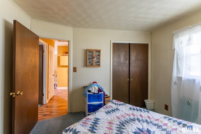 bedroom featuring crown molding, a closet, and wood-type flooring