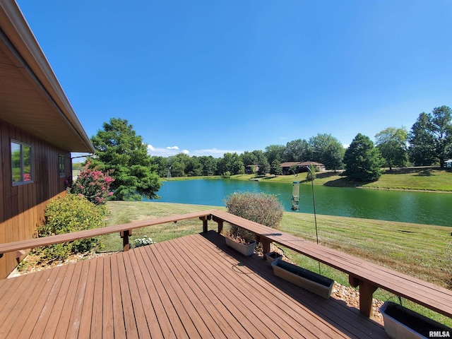 wooden terrace featuring a water view and a yard