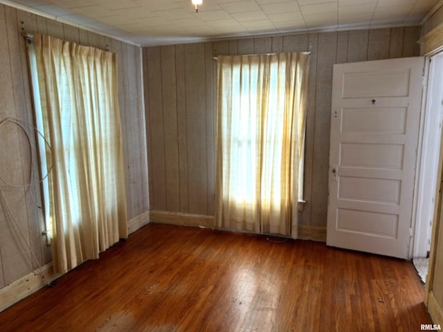 spare room featuring hardwood / wood-style flooring and wooden walls