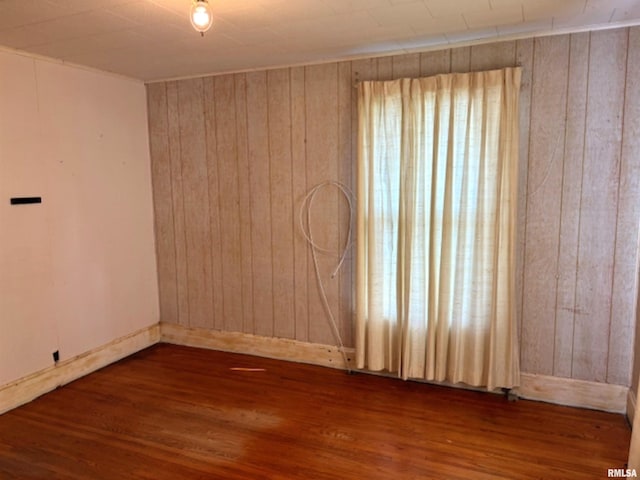 empty room featuring dark hardwood / wood-style floors and wood walls