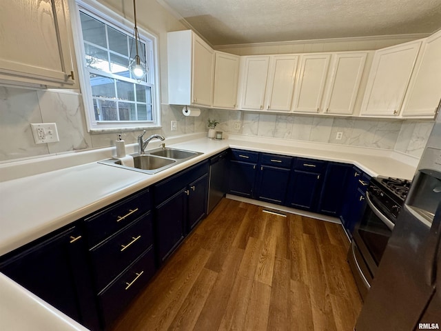 kitchen with black dishwasher, white cabinetry, stainless steel range with gas cooktop, and sink