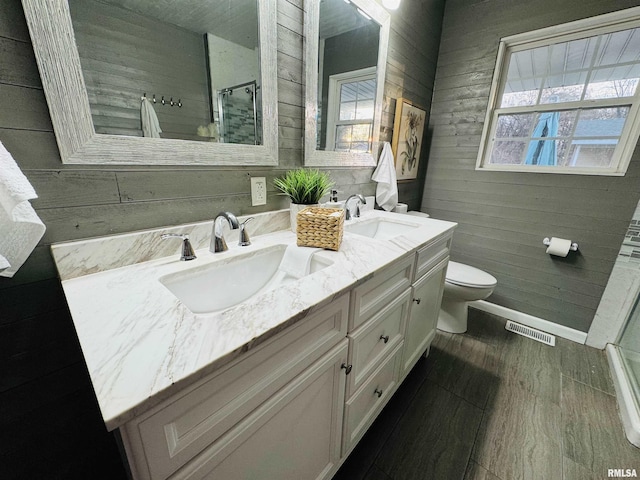 bathroom with vanity, hardwood / wood-style flooring, toilet, and wooden walls