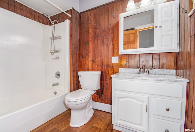 full bathroom with wood walls, shower / bath combination, wood-type flooring, toilet, and vanity