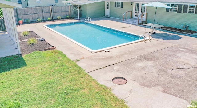 view of swimming pool featuring french doors, a yard, and a patio