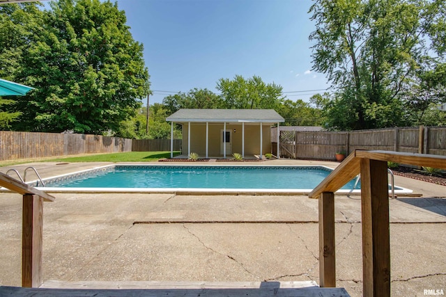 view of pool with a patio and an outdoor structure