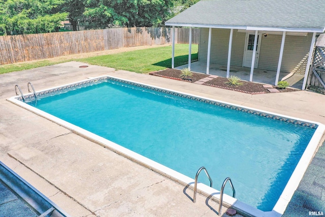 view of swimming pool featuring a lawn and a patio area