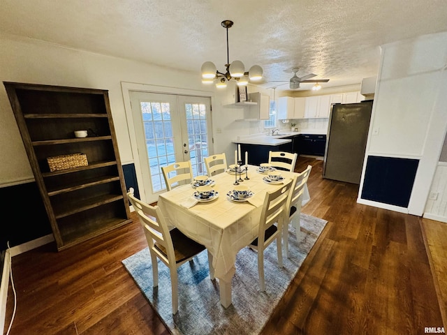 dining room featuring a textured ceiling, ceiling fan with notable chandelier, and dark hardwood / wood-style floors