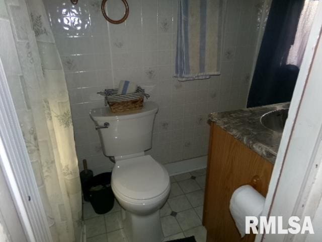 318 Williams St, Rosiclare, IL 62982 - bathroom featuring toilet, walk in shower, tile patterned floors, vanity, and tile walls