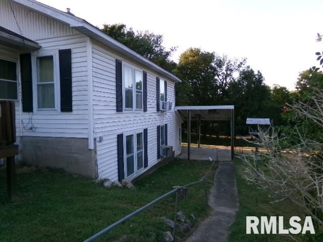 318 Williams St, Rosiclare, IL 62982 - view of property exterior with a lawn, a carport, and cooling unit