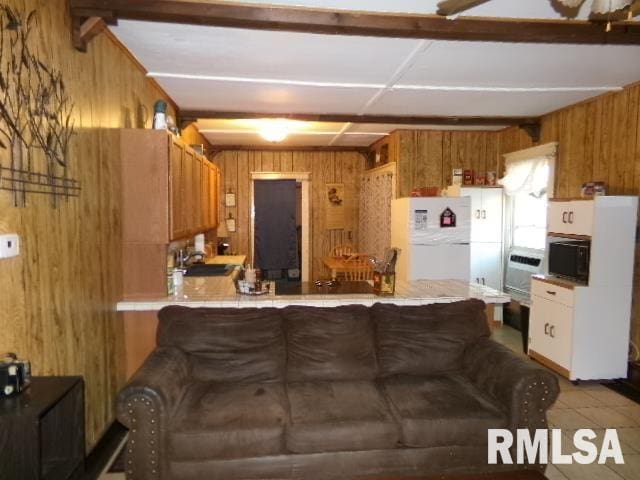 318 Williams St, Rosiclare, IL 62982 - kitchen featuring wood walls, sink, ceiling fan, white refrigerator, and light tile patterned flooring