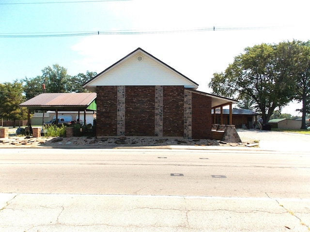 view of front of property with a carport, brick siding, and driveway