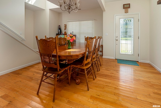 dining area with light wood-type flooring and a chandelier