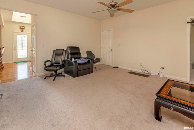 sitting room featuring light colored carpet and ceiling fan