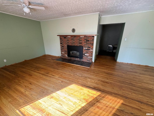 unfurnished living room with a textured ceiling, ceiling fan, hardwood / wood-style floors, and a fireplace