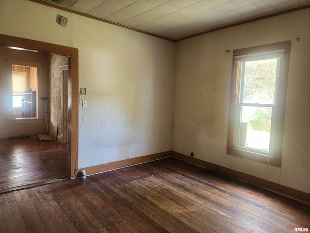 unfurnished room featuring ornamental molding and dark hardwood / wood-style floors