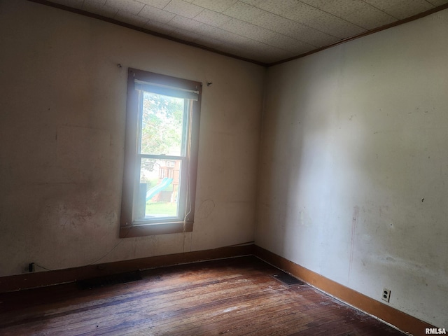 unfurnished room with hardwood / wood-style flooring and ornamental molding