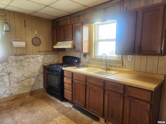 kitchen with a drop ceiling, black range with gas stovetop, and sink