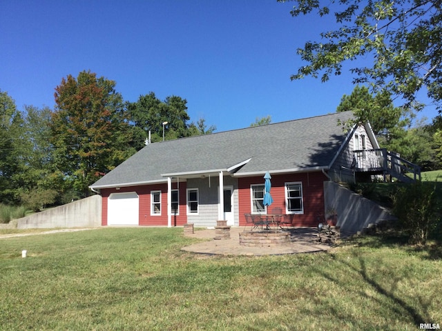 view of front of home with a front lawn, a garage, and a patio area