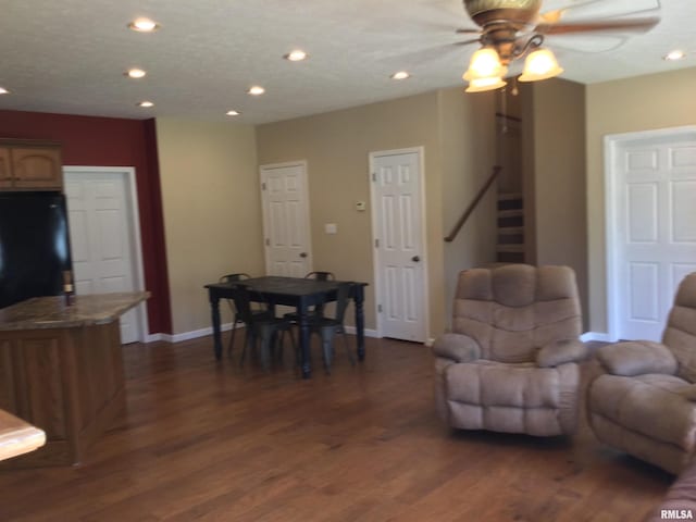 living room featuring ceiling fan and dark hardwood / wood-style flooring