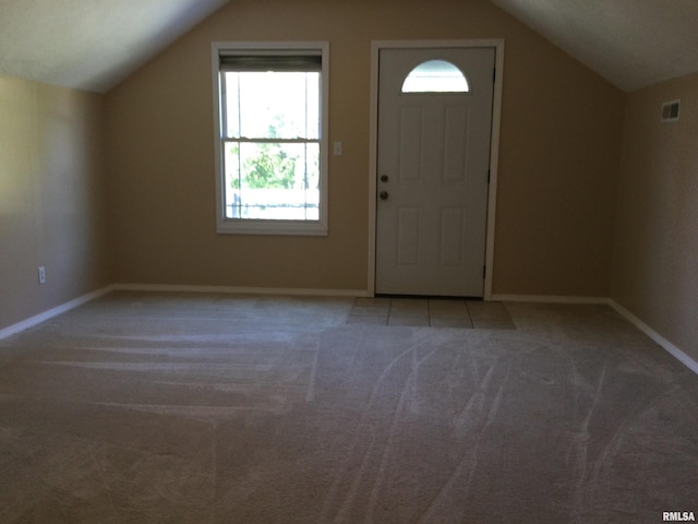 entrance foyer featuring light colored carpet and vaulted ceiling