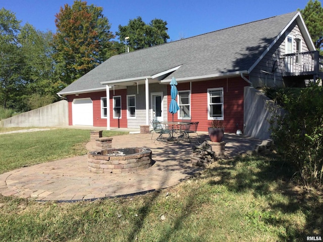 view of front of house featuring a garage, a fire pit, a front lawn, and a patio