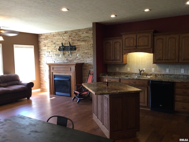 kitchen featuring a center island, sink, black dishwasher, dark wood-type flooring, and ceiling fan