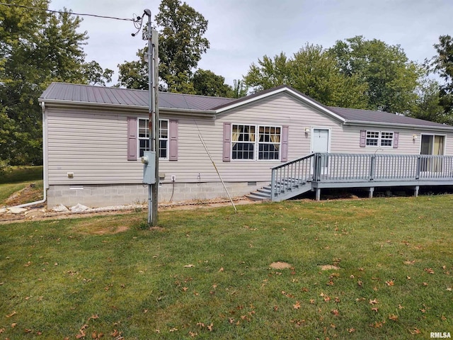 rear view of property featuring a deck and a lawn