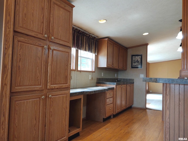 kitchen with light wood-type flooring and a textured ceiling