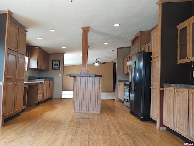 kitchen with a textured ceiling, stainless steel stove, light hardwood / wood-style floors, ceiling fan, and black fridge