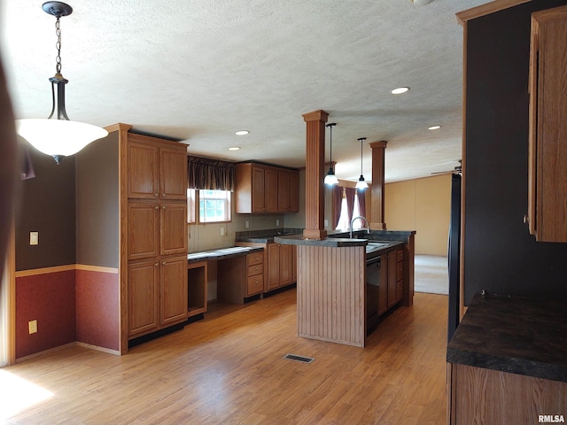 kitchen with light wood-type flooring, decorative light fixtures, a center island, and sink