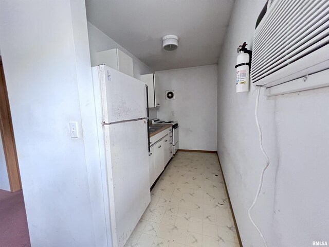 kitchen featuring light floors, white cabinets, dark countertops, and white appliances
