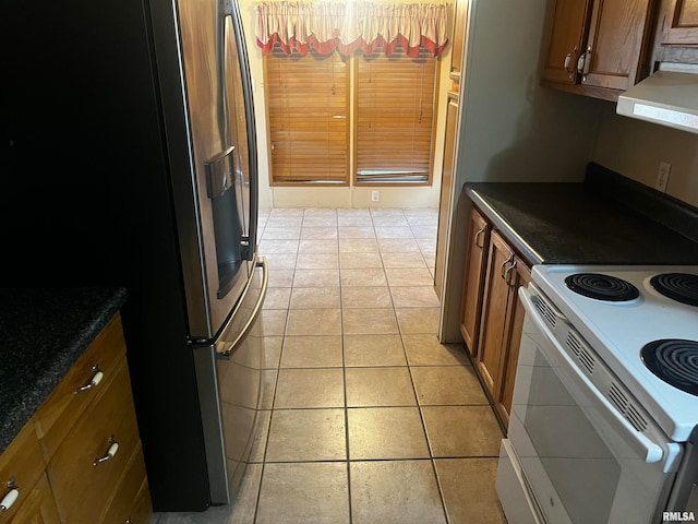 kitchen featuring ventilation hood, stainless steel fridge, and white range with electric cooktop