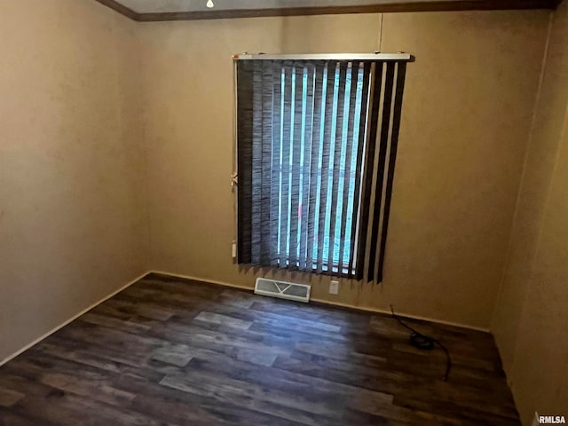 spare room with dark wood-type flooring and ornamental molding