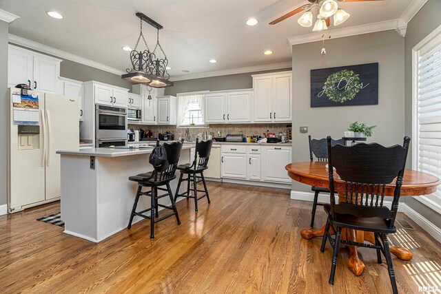 kitchen with light hardwood / wood-style flooring, appliances with stainless steel finishes, and white cabinets