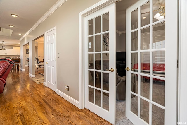 hallway with wood-type flooring, crown molding, and french doors