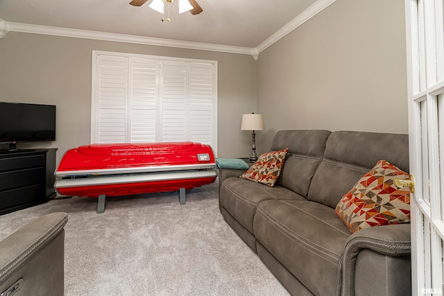 carpeted living room with crown molding and ceiling fan