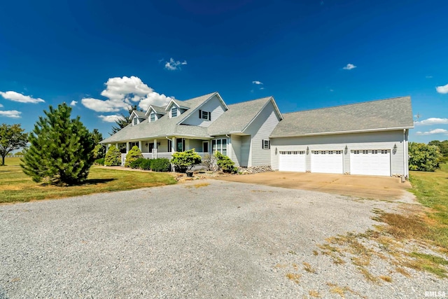 cape cod home with a garage, a front yard, and covered porch