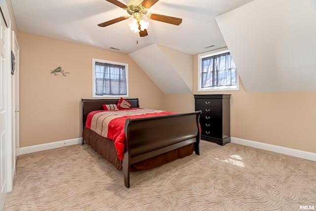 bedroom featuring multiple windows, light colored carpet, vaulted ceiling, and ceiling fan