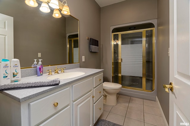 bathroom with tile patterned flooring, vanity, toilet, and walk in shower