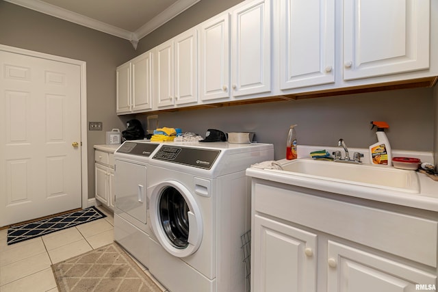 laundry area featuring cabinets, ornamental molding, washing machine and clothes dryer, sink, and light tile patterned flooring