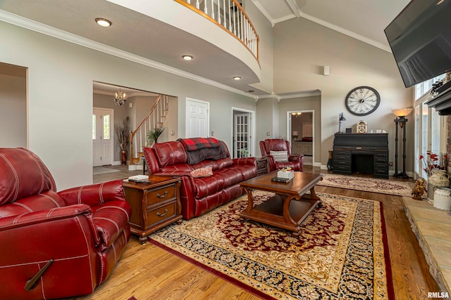 living room featuring crown molding, light hardwood / wood-style flooring, and high vaulted ceiling