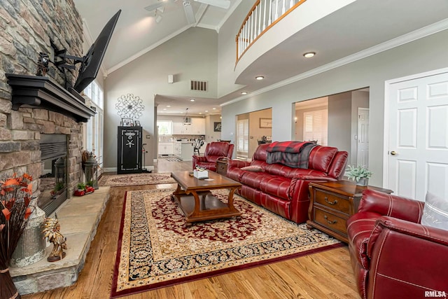 living room featuring plenty of natural light, ceiling fan, light wood-type flooring, and a fireplace